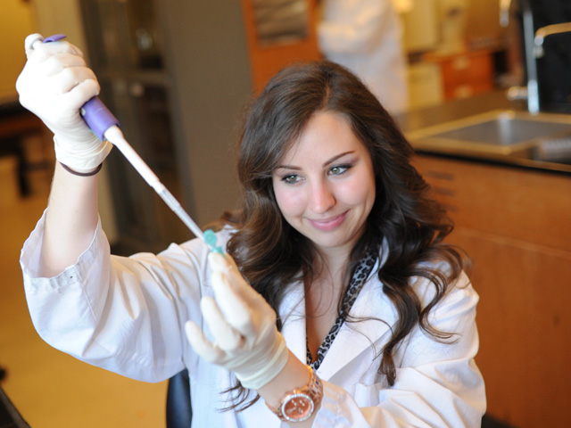 A professor in a lab coat doing an experiment.