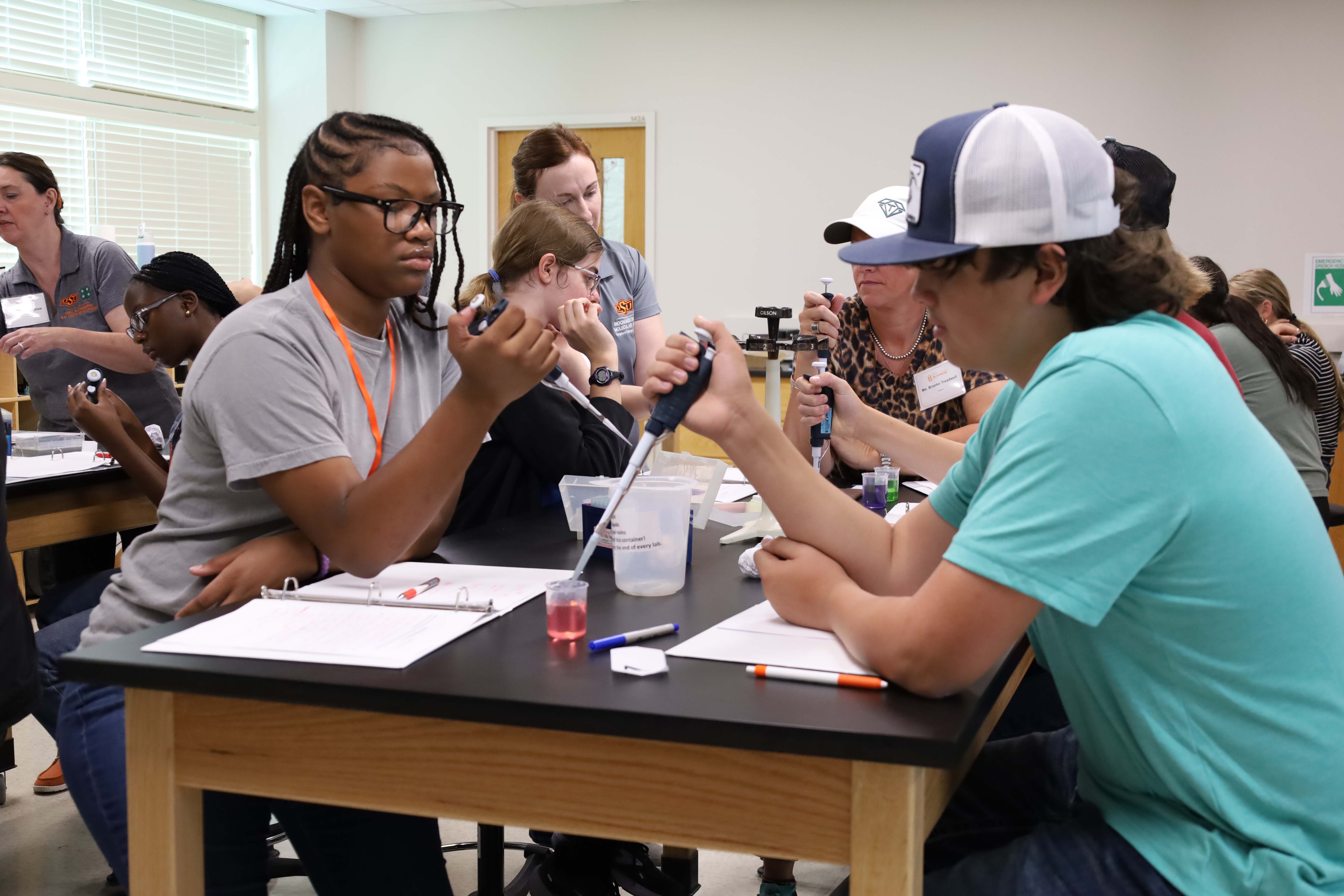 Students practicing lab techniques with pipettes