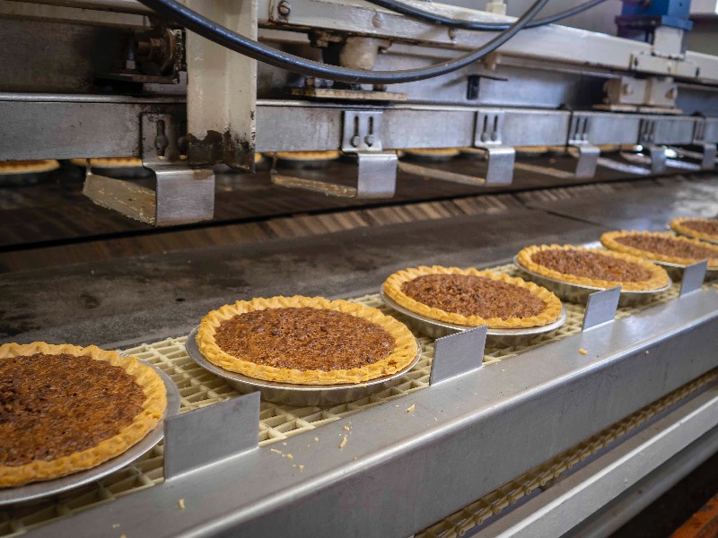 Pecan pies on processing line in a production facility.