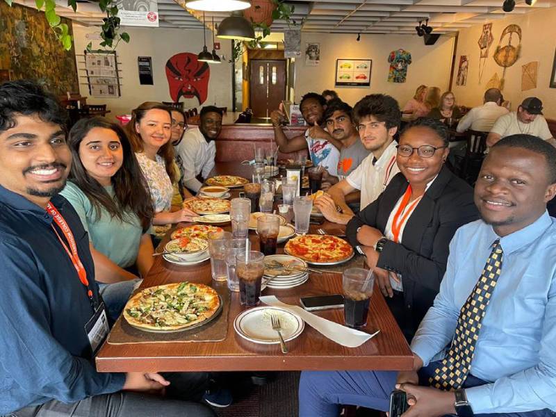 Students sitting at a long table eating a meal together.