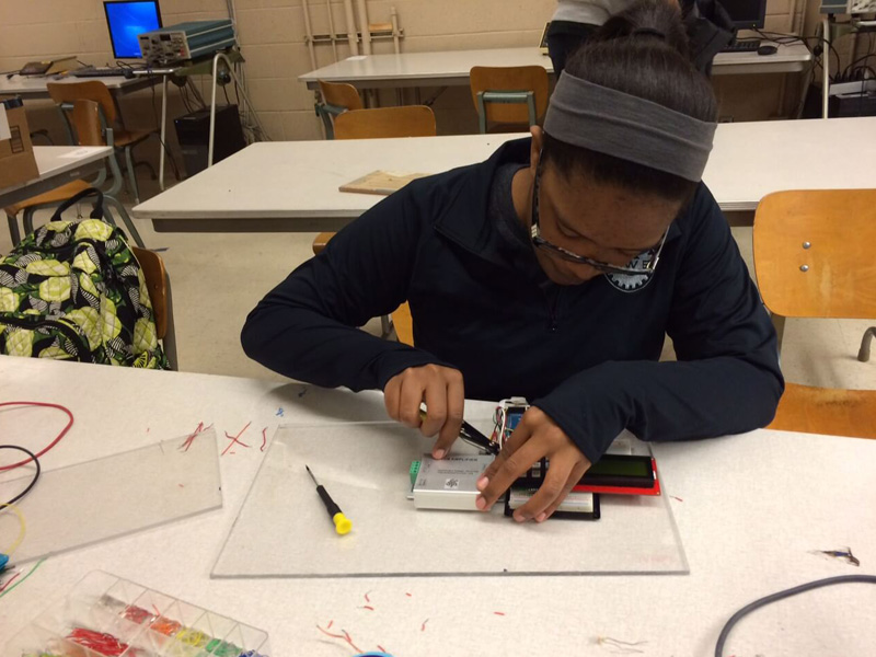 Sneior design student works on a programing board