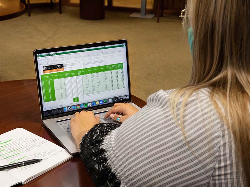 A girl typing on a laptop.