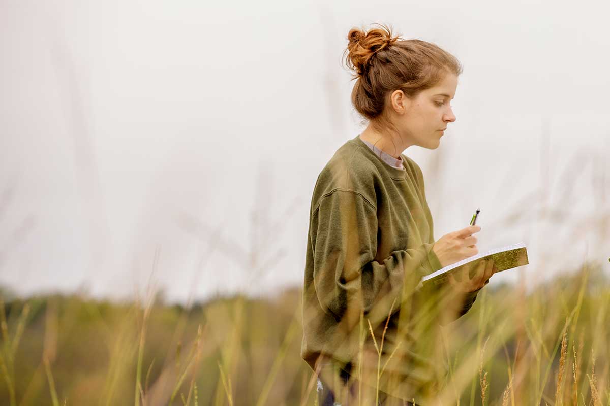Student researching in a field