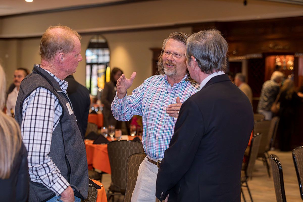 Dr. Craig Davis talking two gentleman.