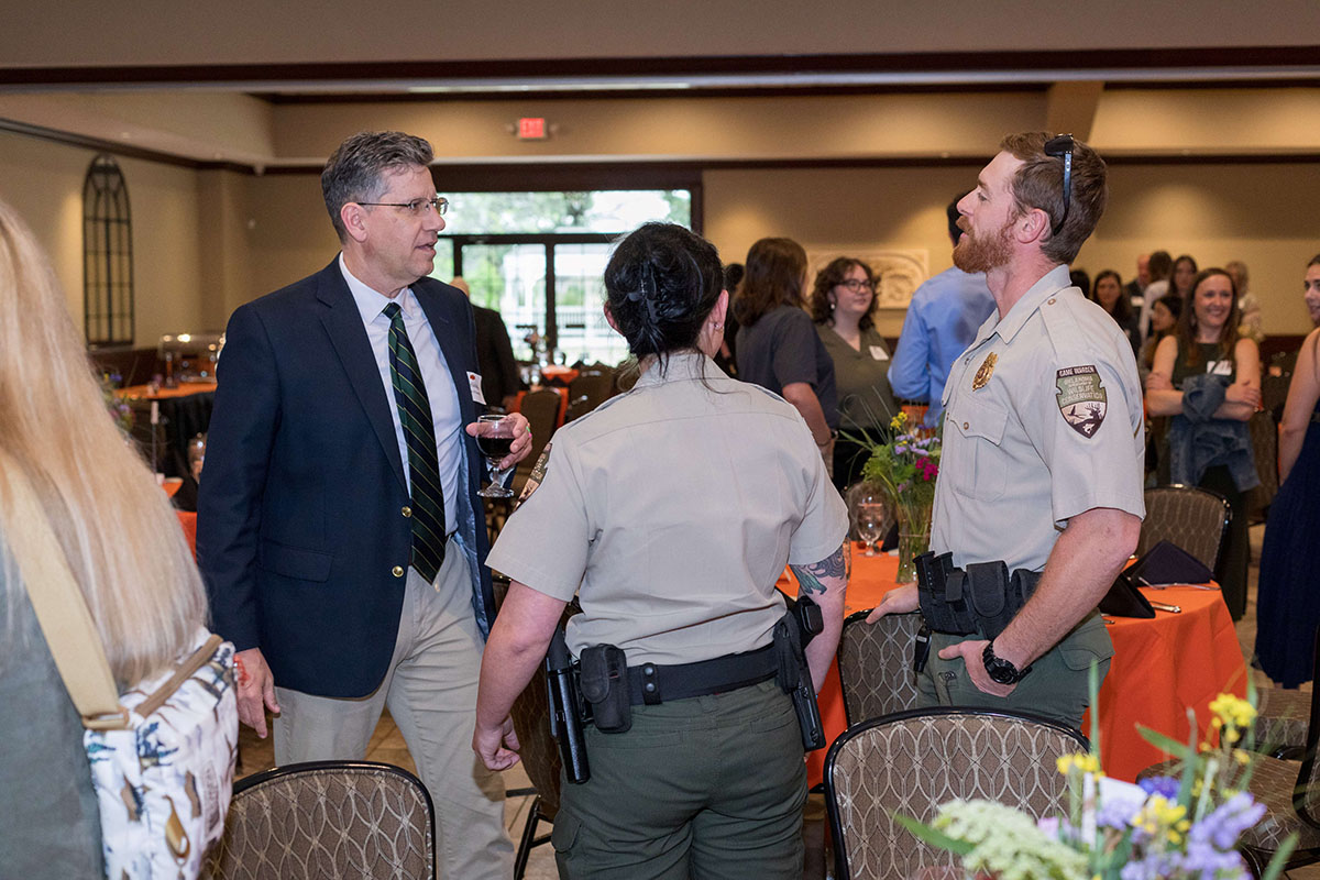 Dr. Timothy O'Connell is talking to two people in uniform.