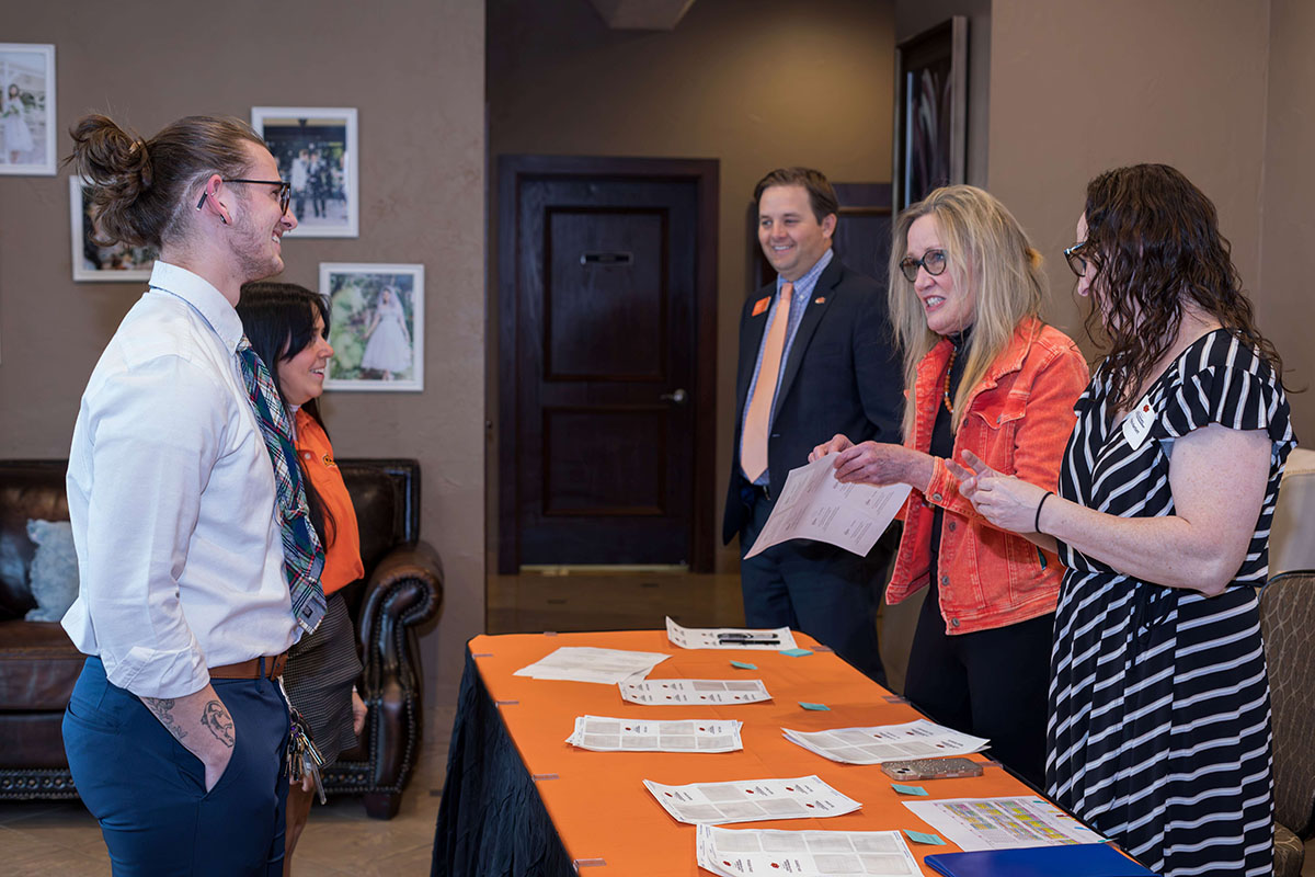 A group of people standing around a table.