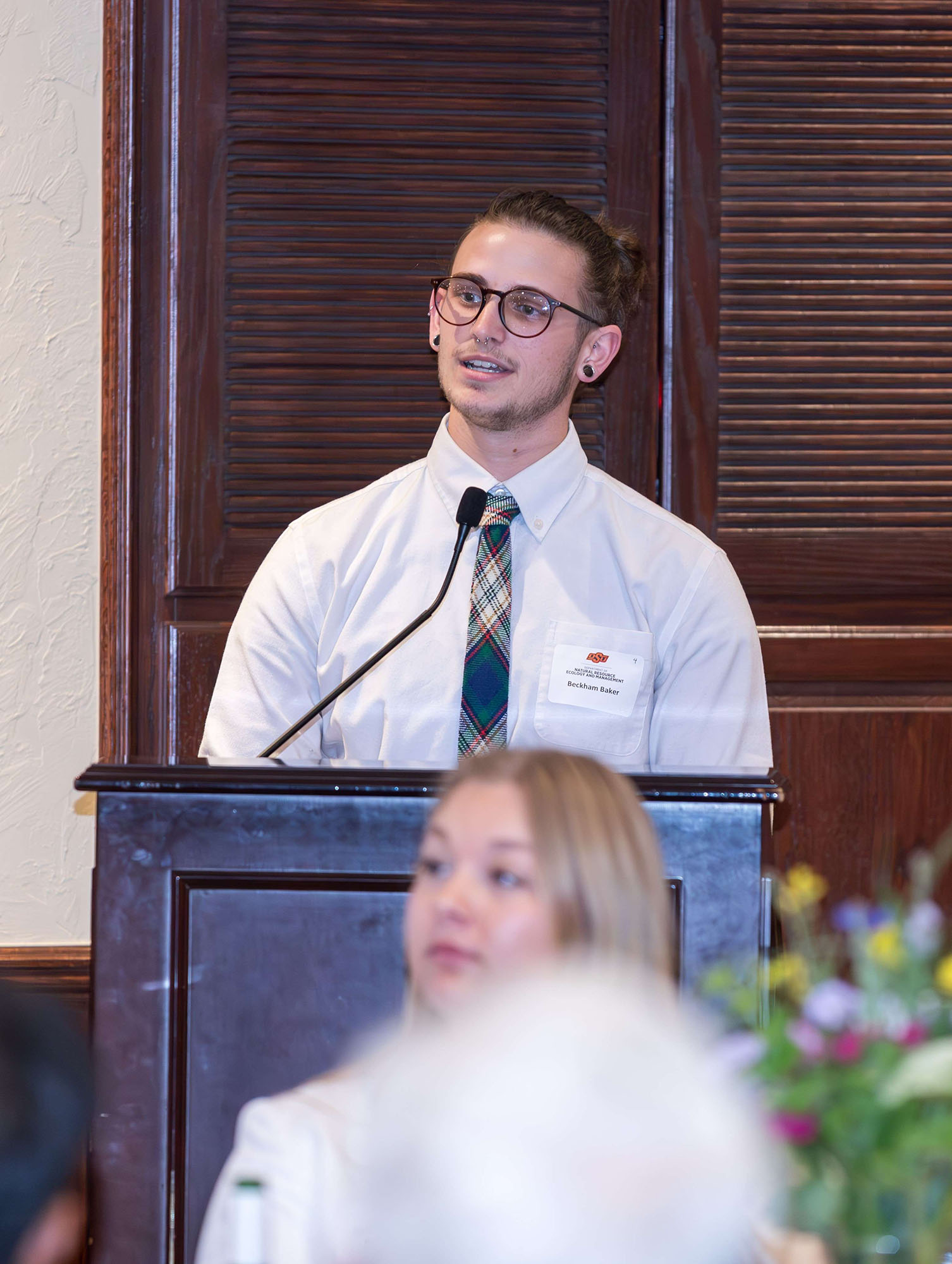 Baker Backham speaking behind the podium.