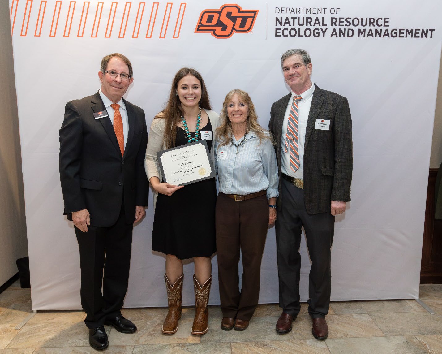 Kayla and Jim Ansley next to Jesse and Bruce accepting their Graduate Student Scholarship award.