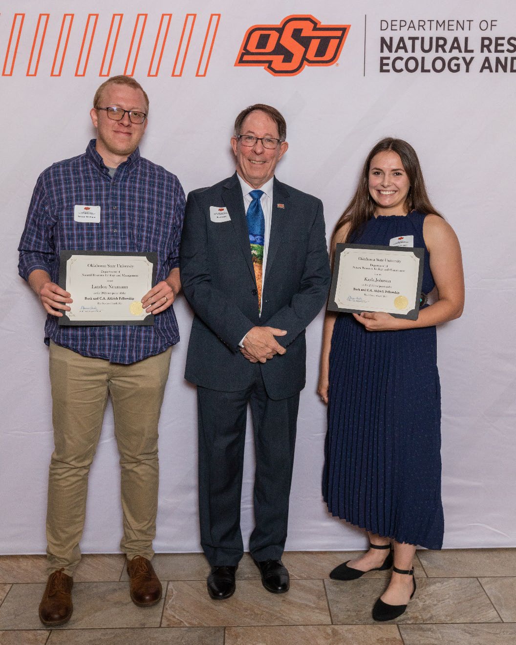 Landon and Kayla holding their award next to Dr. Jim Ansley.