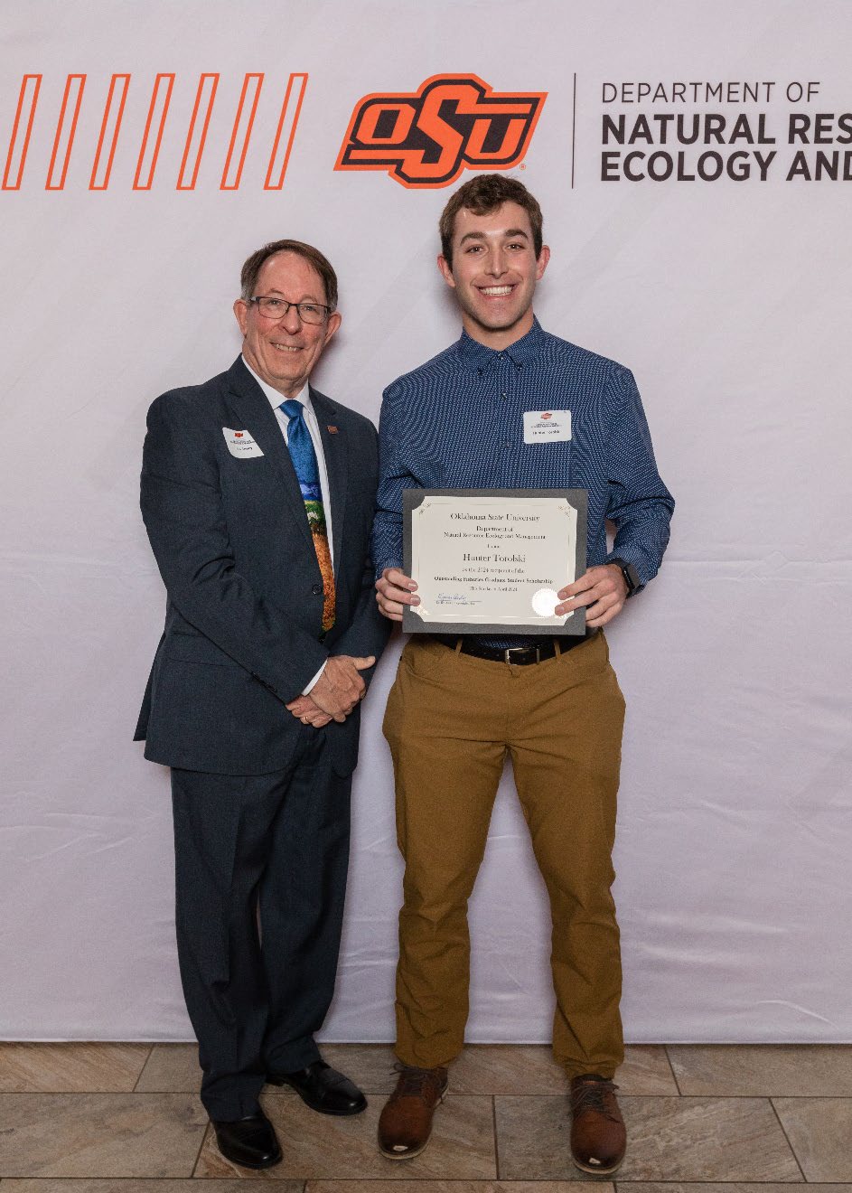 Hunter Torolski holding his award next to Dr. Jim Ansley.