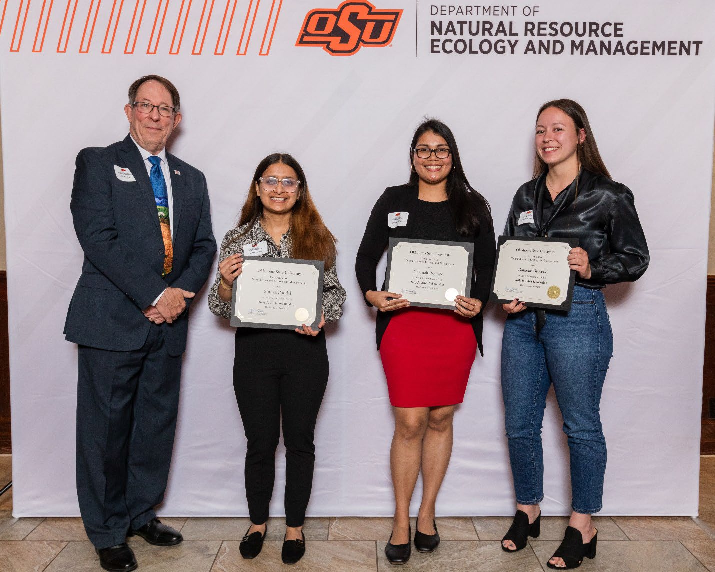 Jim Ansley, Sonika Poudel, Chamali Rodrigo and Danielle Brosend holding their award.