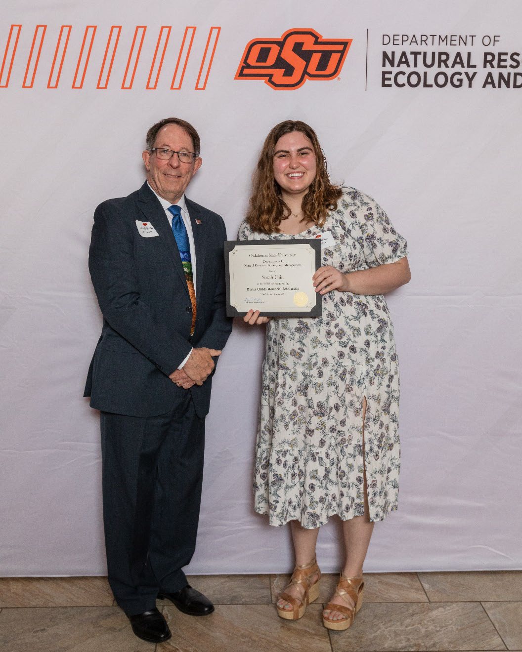 Sarah is accepting her award from Dr. Jim Ansley.