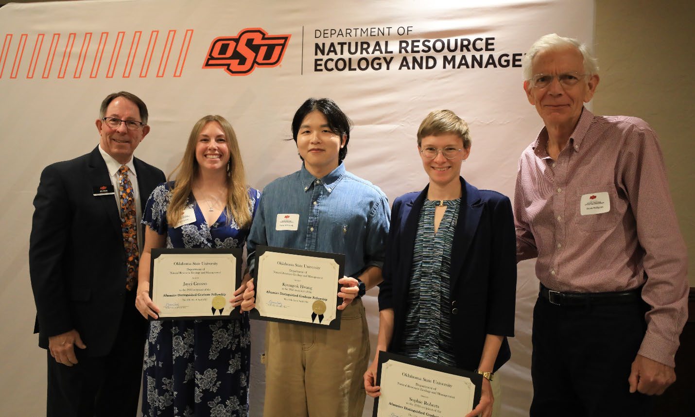 Dr. Jim Ansley with three scholarship awardees holding their plaque and Dr. Steve Hallgren.