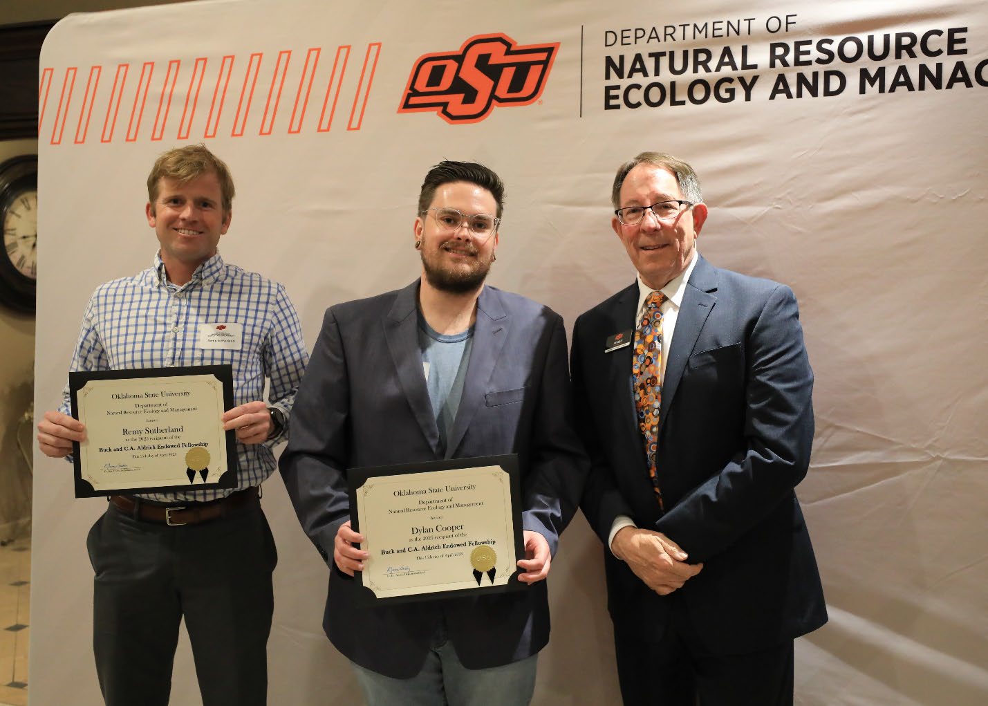 Remy Sutherland and Dylan Cooper holding their plaque next to Dr. Jim Ansley.