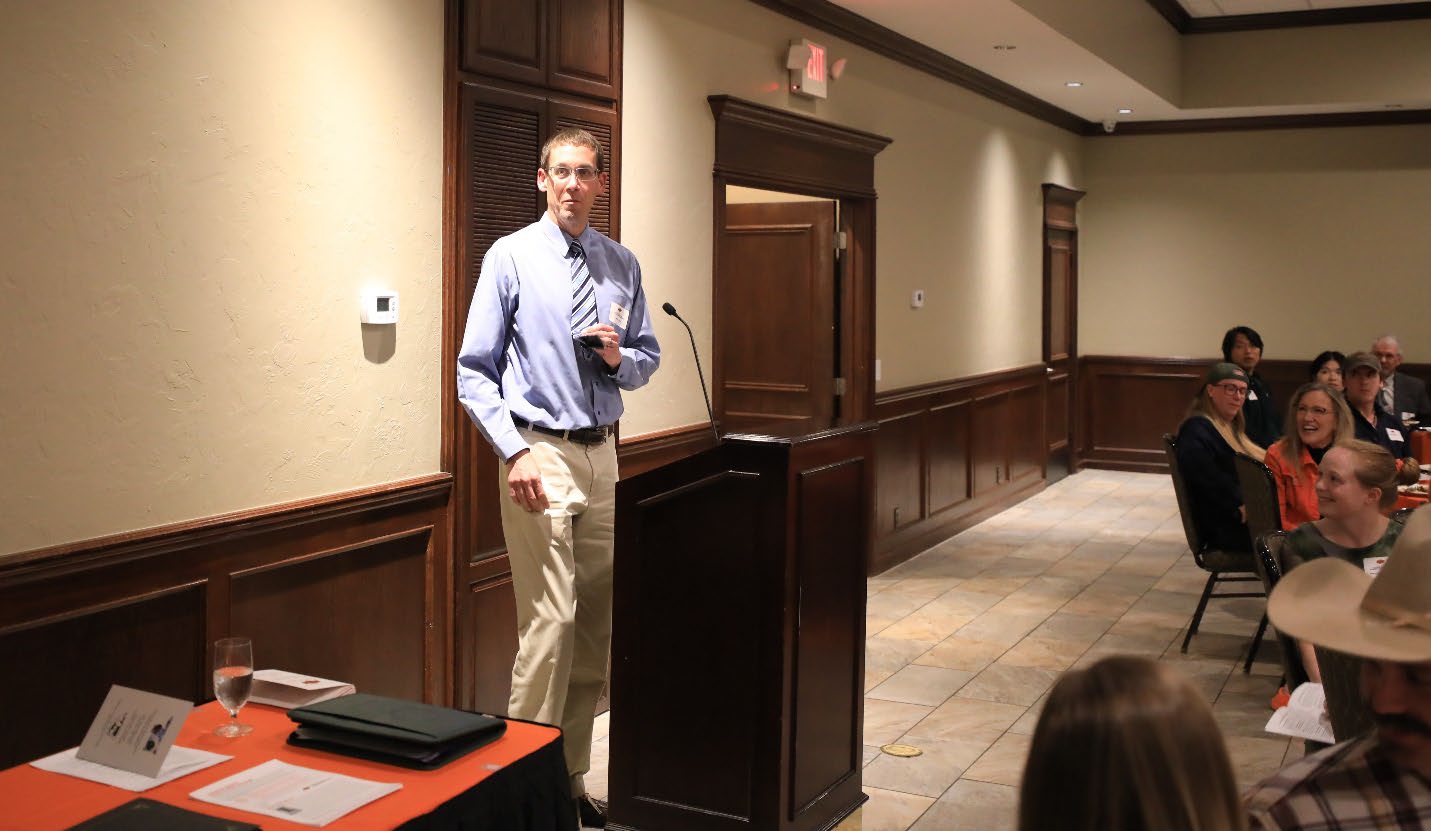 Dr. Scott Loss standing behind a podium at an award ceremony.