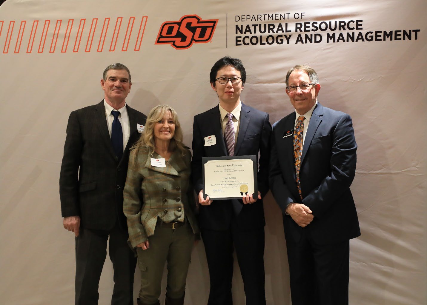 Tian Zhang holding his award with Louise and Bruce Burton and Dr. Jim Ansley.