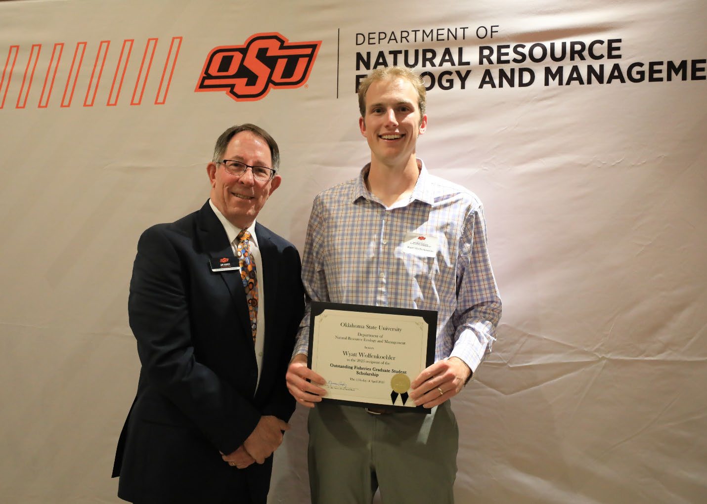 Wyatt Wolfenkoehler holding his plaque next to Dr. Jim Ansley.