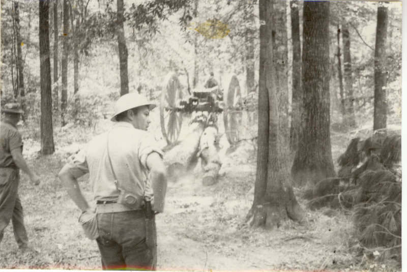 Students are standing in the forest near a cannon.