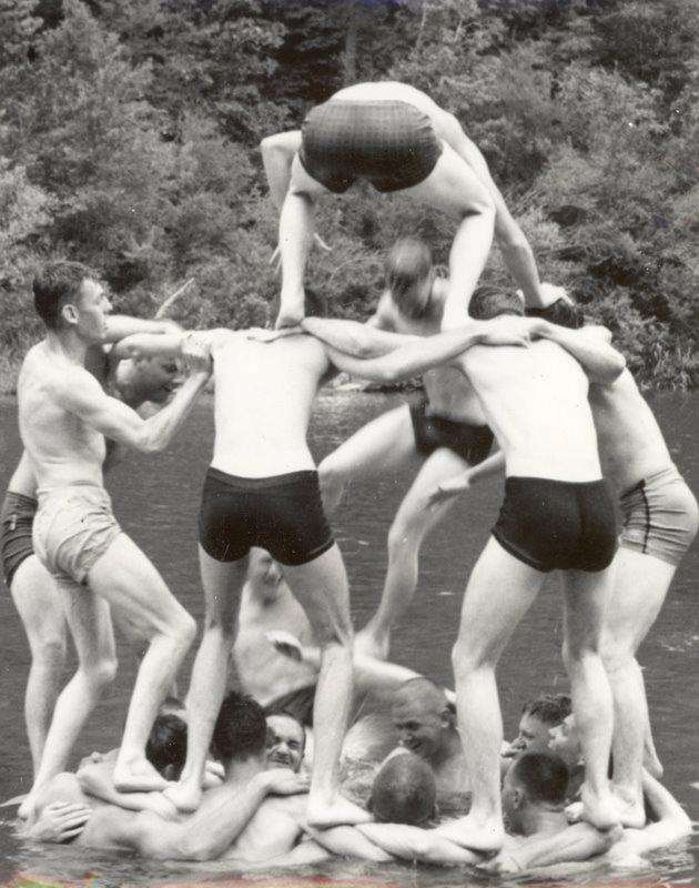 A group of students in the water trying to build a pyramid formation.