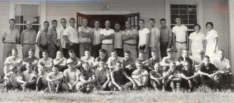 The forestry camp group is sitting and standing for a group photo.