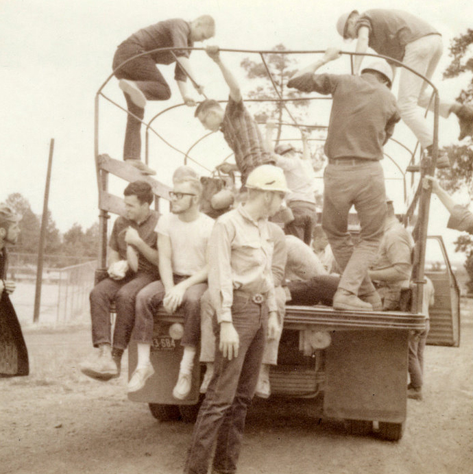 A group of people sitting on the back of a truck.