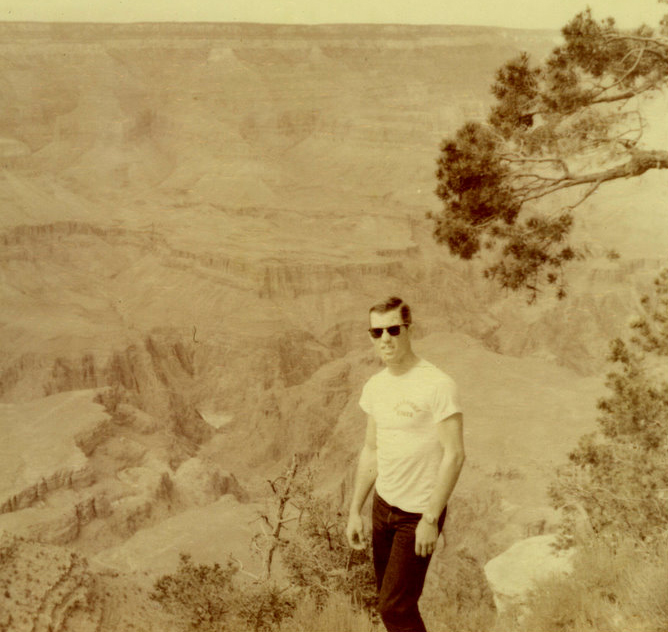A person standing on rocks, smiling for the camera.