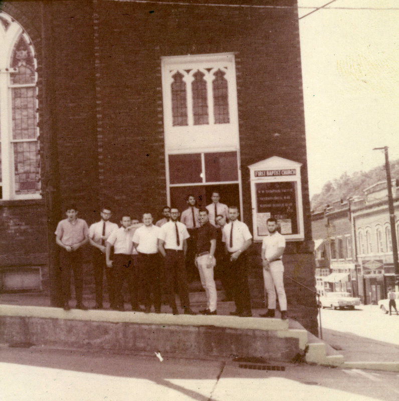 A group of people standing outside a church.