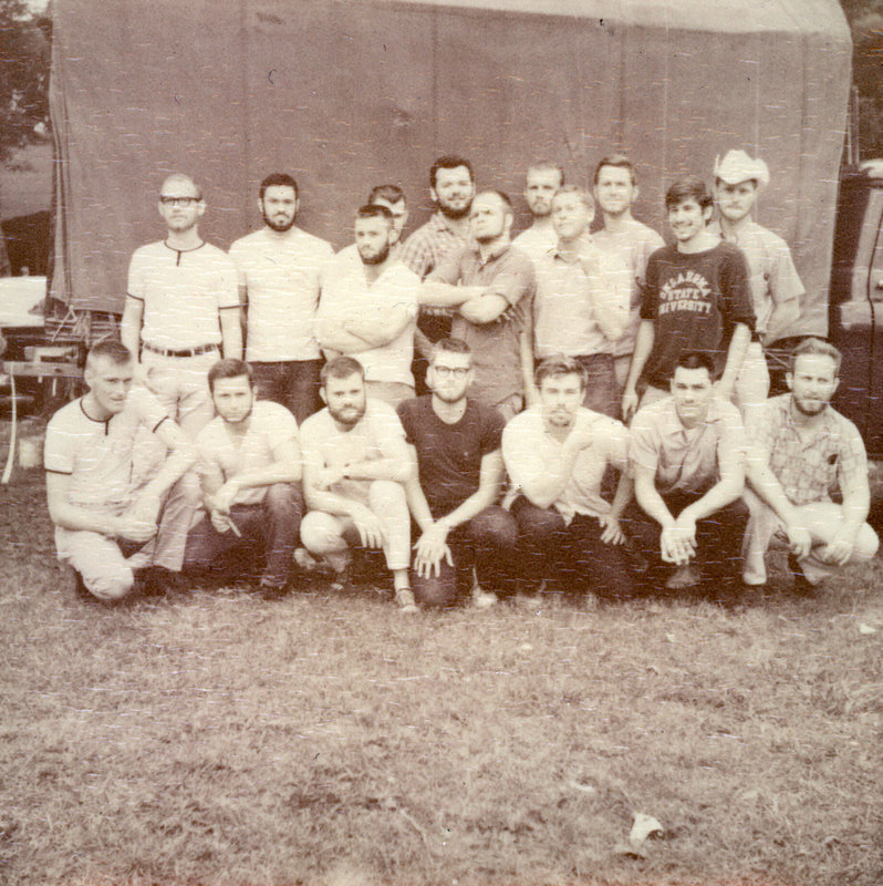A group of students sitting outside in front of a building.