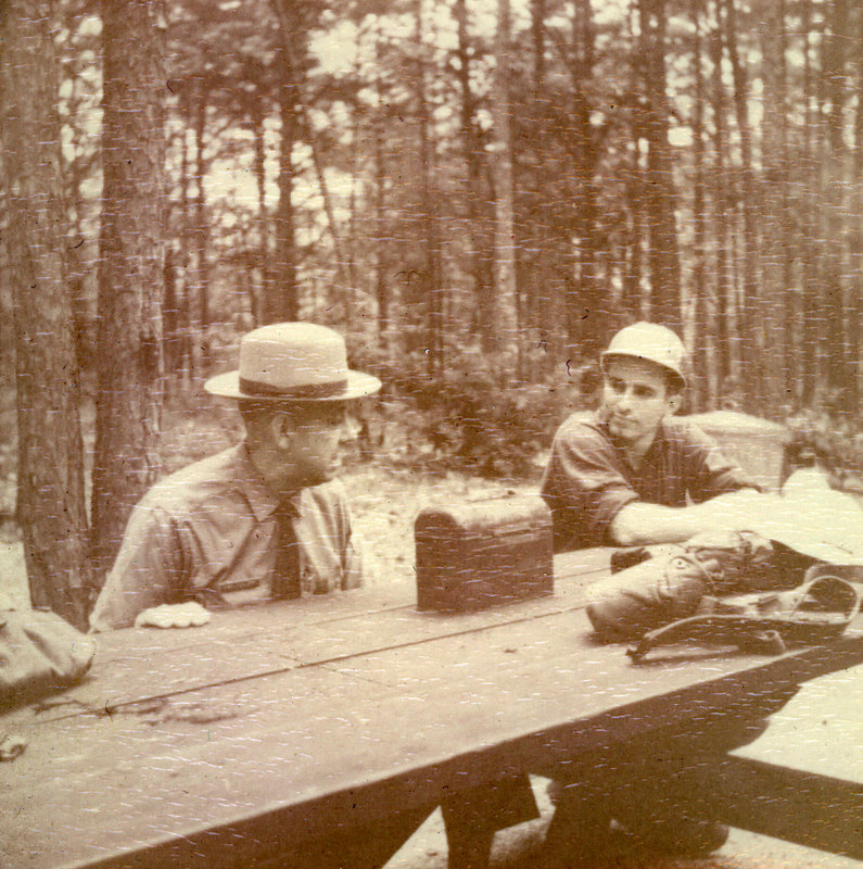 A couple of people sitting at a picnic bench.