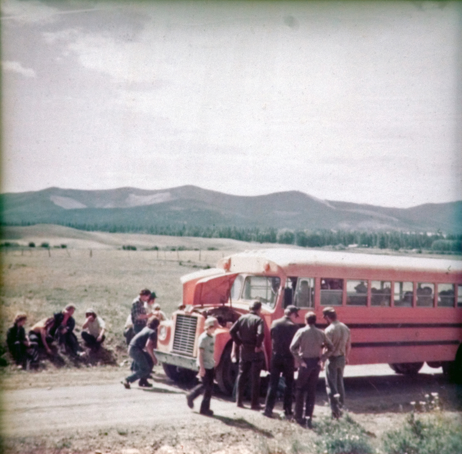 A group of people standing around a school bus.