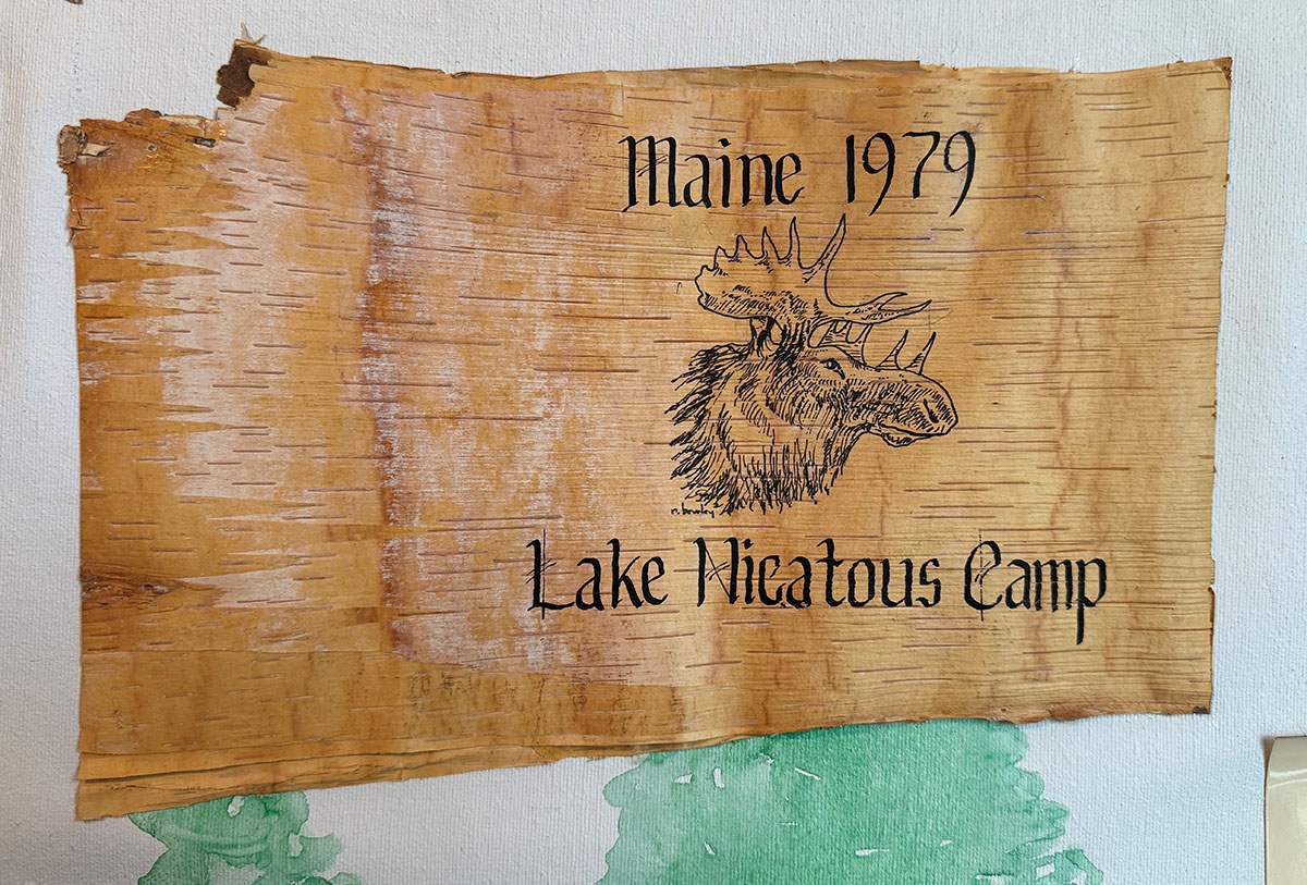 A wooden sign with a moose in the middle and text on top "Maine 1979" and text on the bottom "Lake Nicatous Camp".