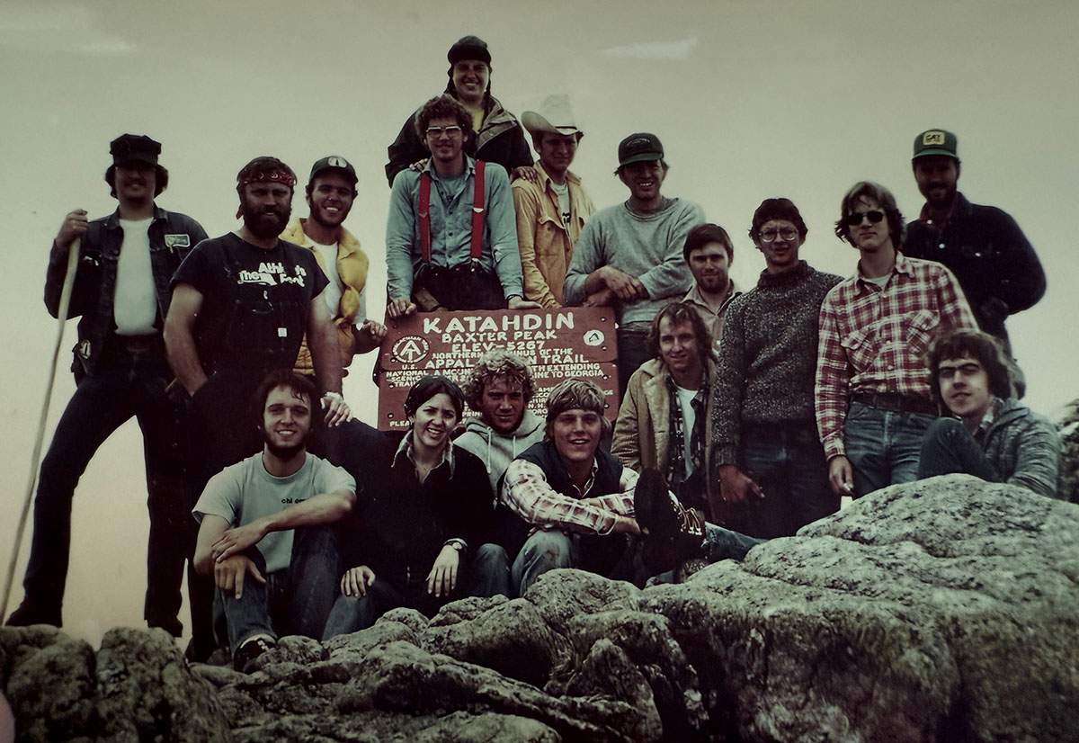 The OSU Undergraduate students from lake Nicatous camp gathering on a big rock around a sign with the header "Katahdin".