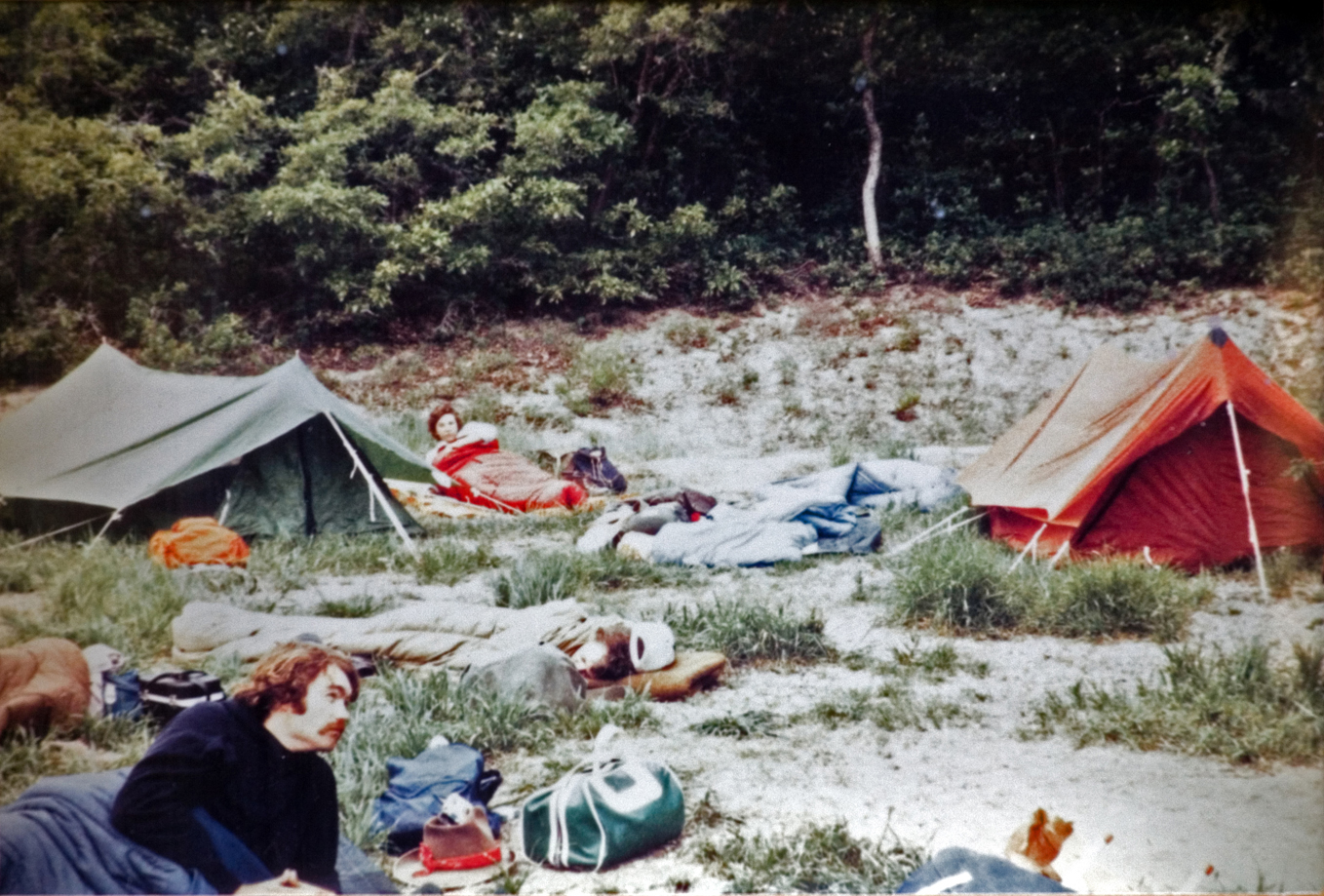 Students lounging at tent set ups while at the campsite.