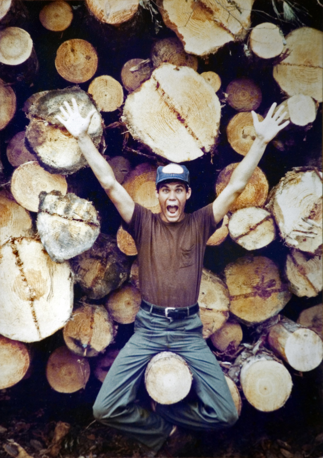 A student sitting on a cut down log.