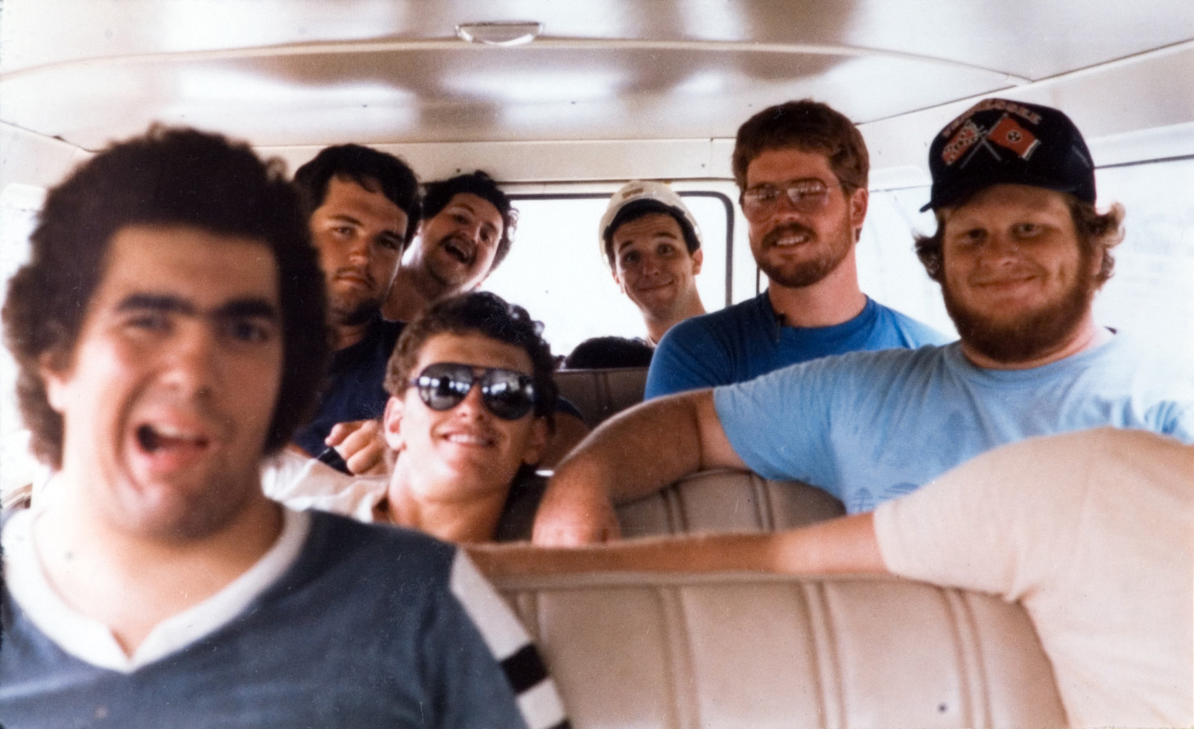 Seven students sitting in a van as they go for a ride.