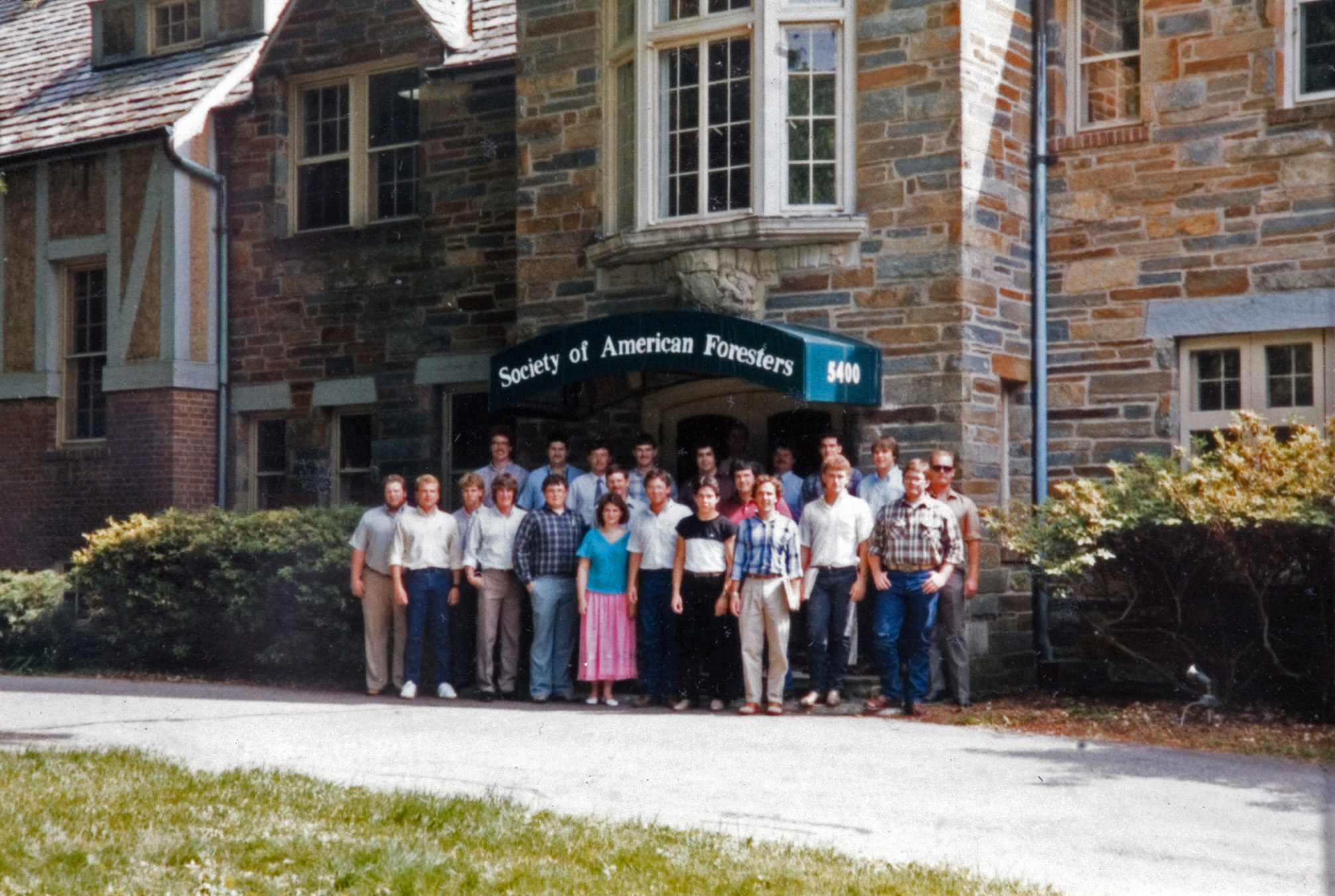 A group of campers standing outside of the Society of American Foresters building for a group photo.