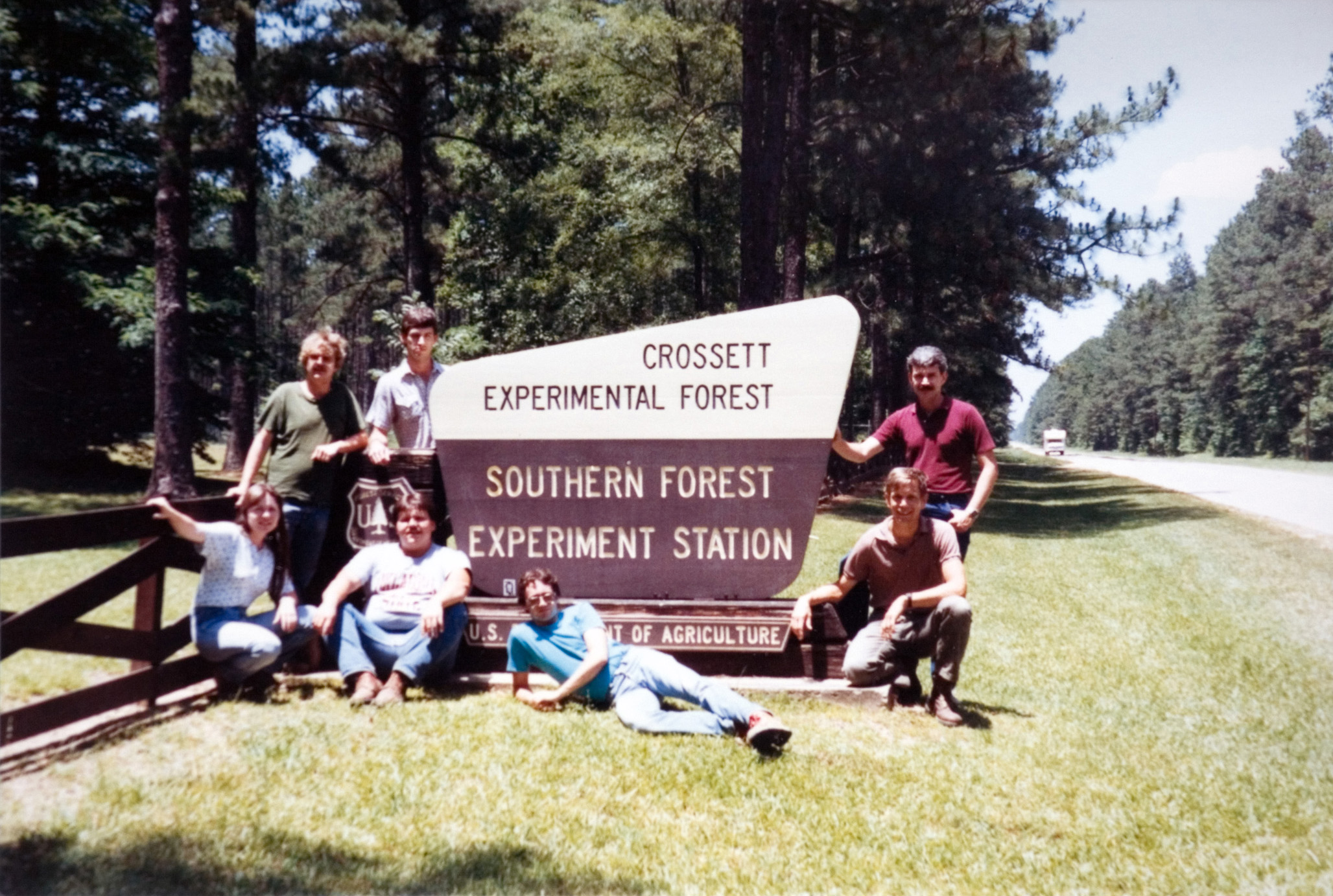 Students pose at the Crossett Forest Experimental Stationsign.