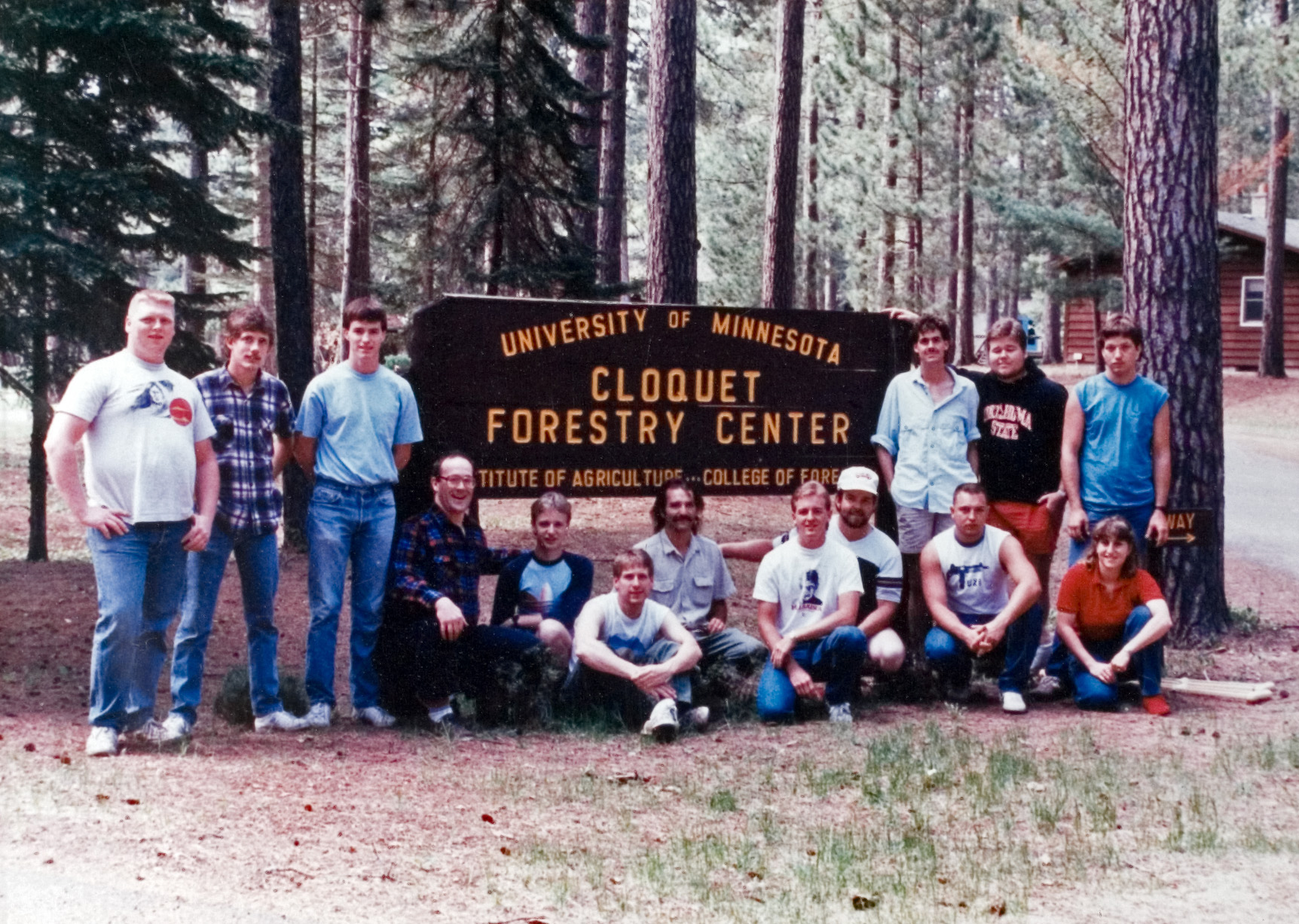 15 students from the Forestry camp posing next to the Cloquet Forestry Center sign outside.