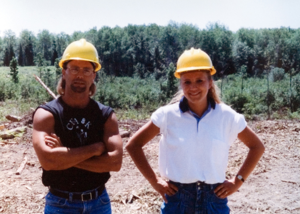 Two students in hardhats pose for the camera at the jobsite.