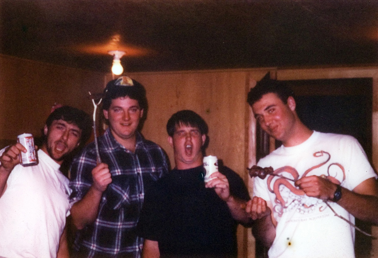 Students cheer as they enjoy food and drinks inside a cabin.