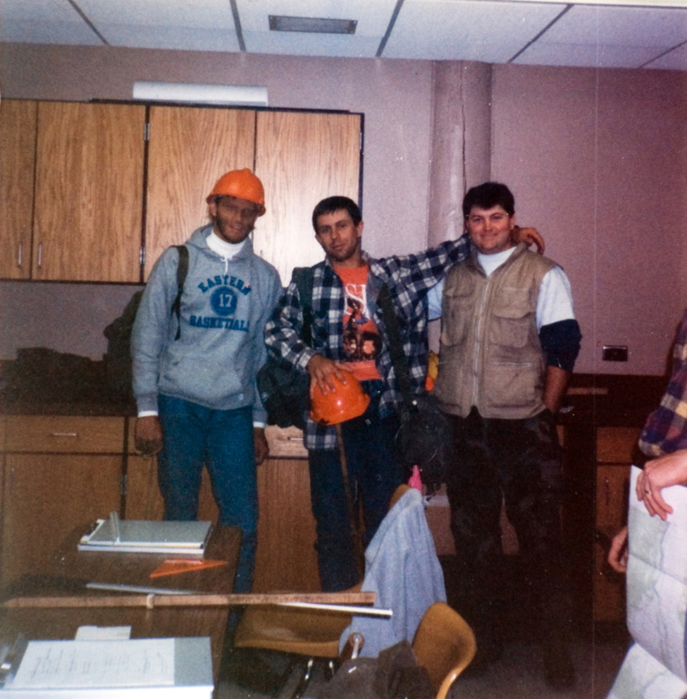 People standing inside a classroom.