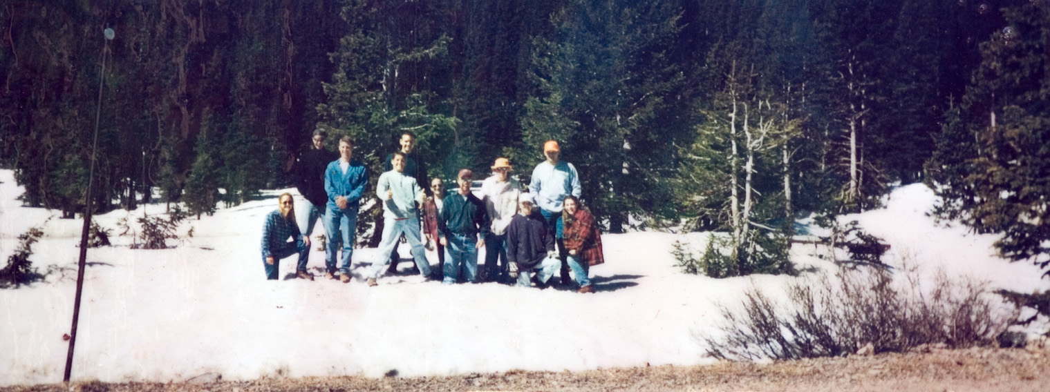 A group of 11 students standing on a patch of snow outside for their photo to be taken.