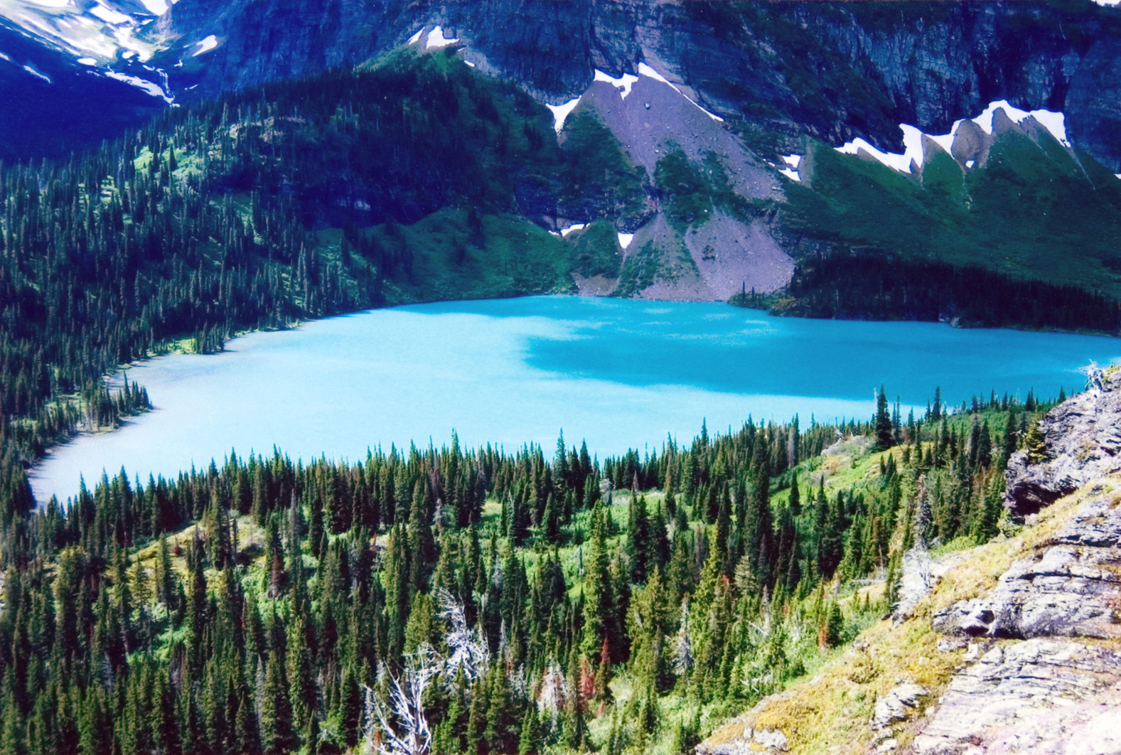 A scenic view from above of a mountain valley and lake.