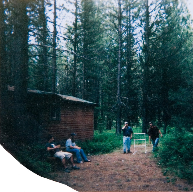 Students lounging outside a cabin in the woods.