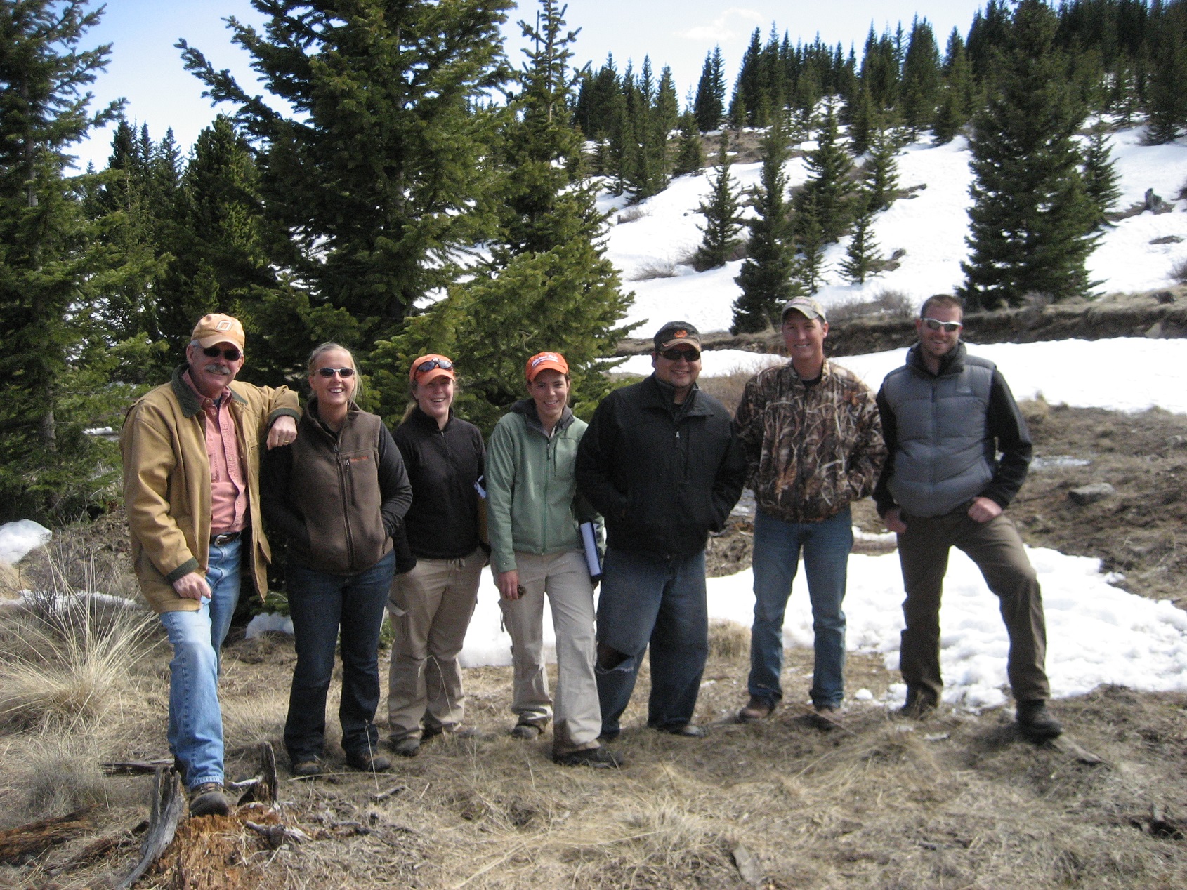 A group of participants posing for a group photo in a snowy wooded area.