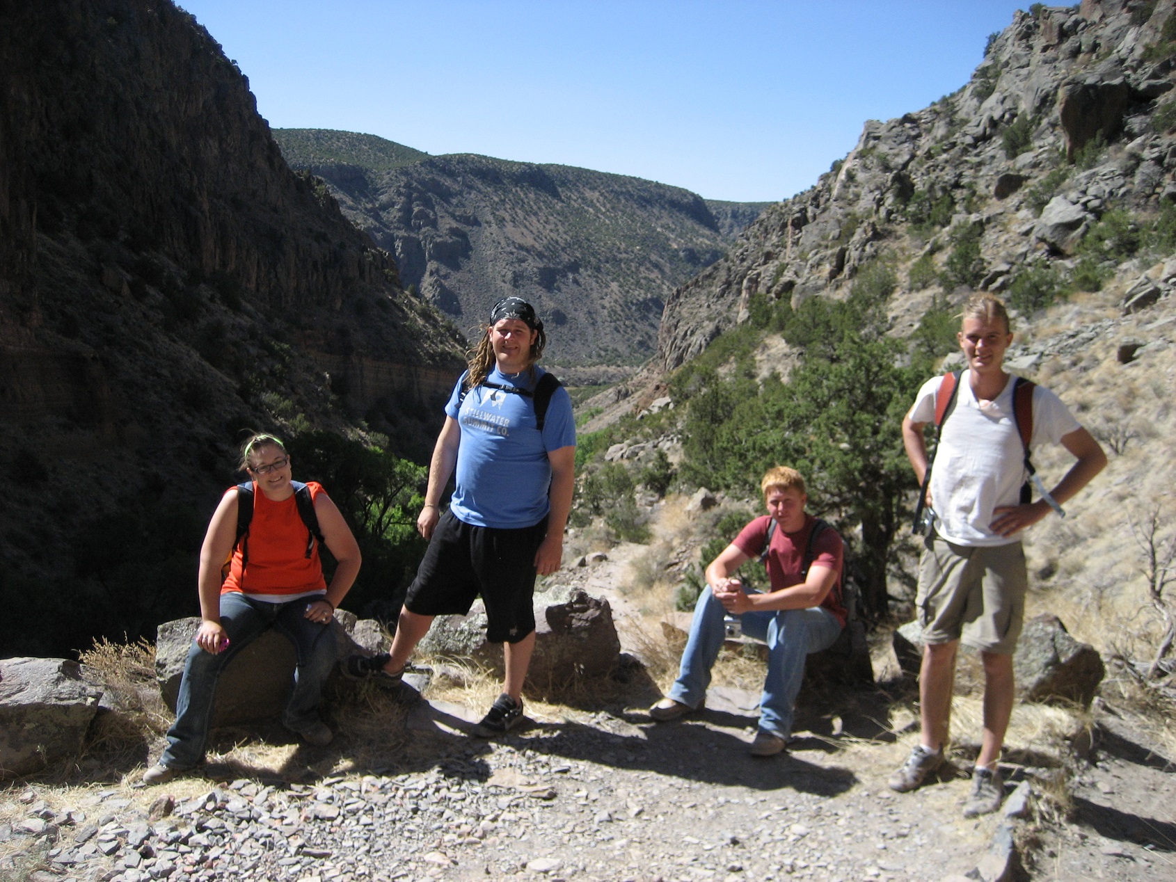 Four participants sitting in a valley between two mountains.