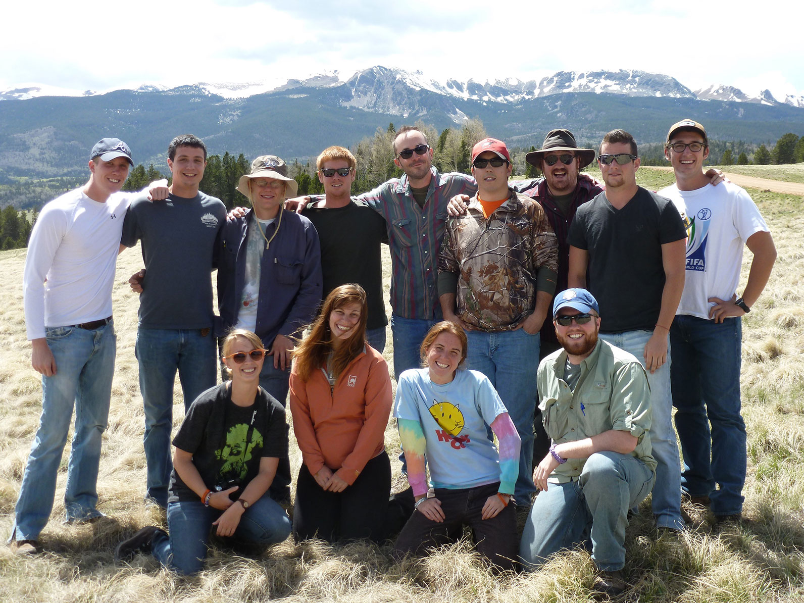 Participants standing and kneeling in a valley.
