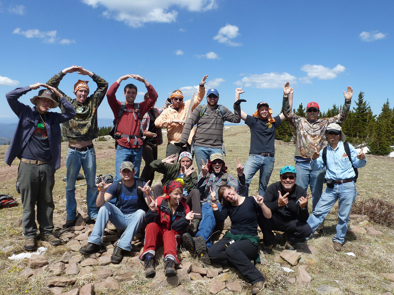 Students in a valley making "O.S.U." symbols with their arms.