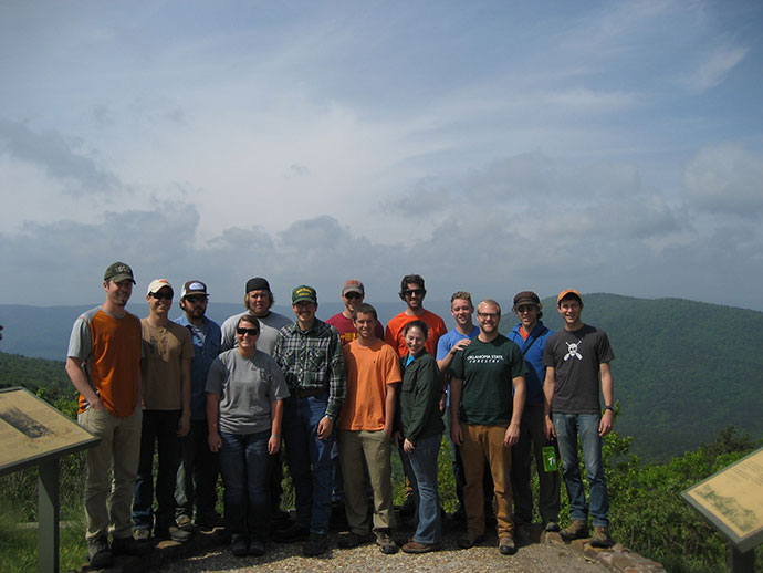 A large group photo of participants standing at an overlook smiling for the camera.