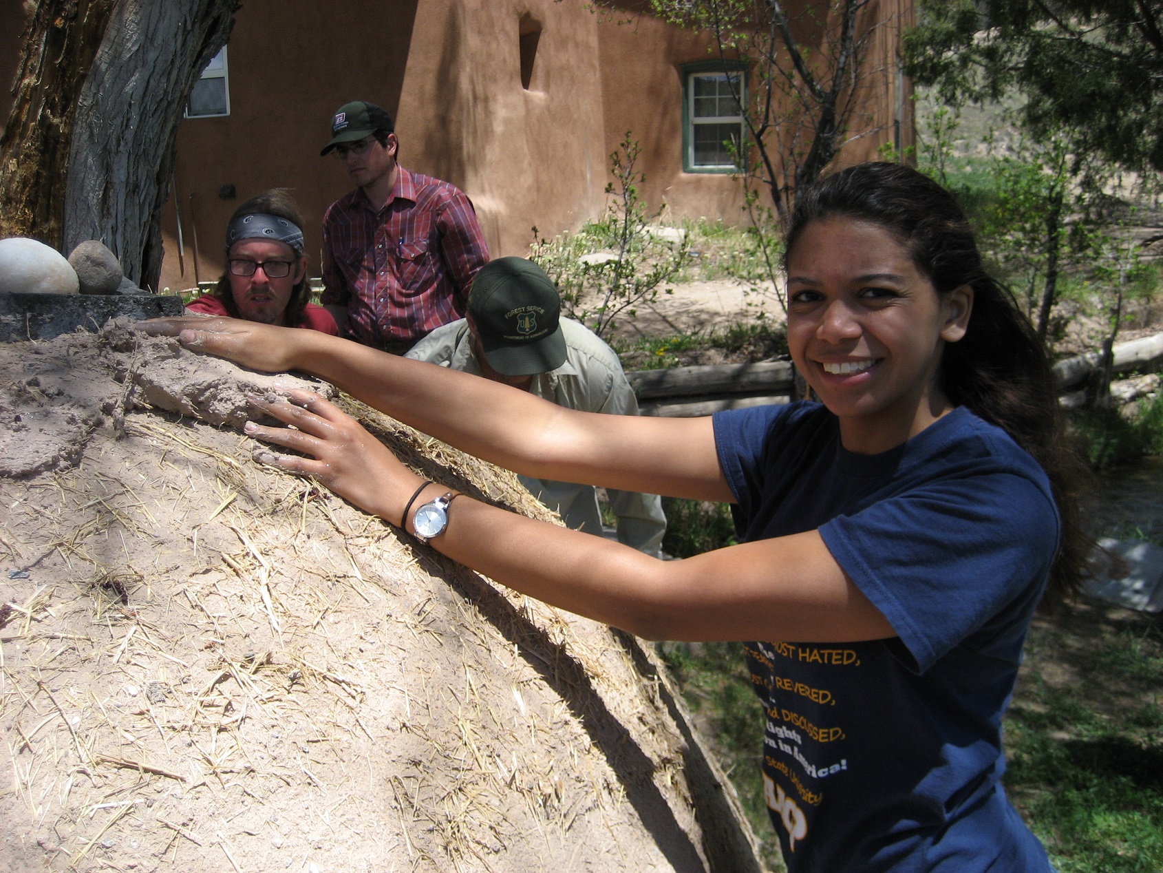 A couple of participants standing around and working on a mound of wood.